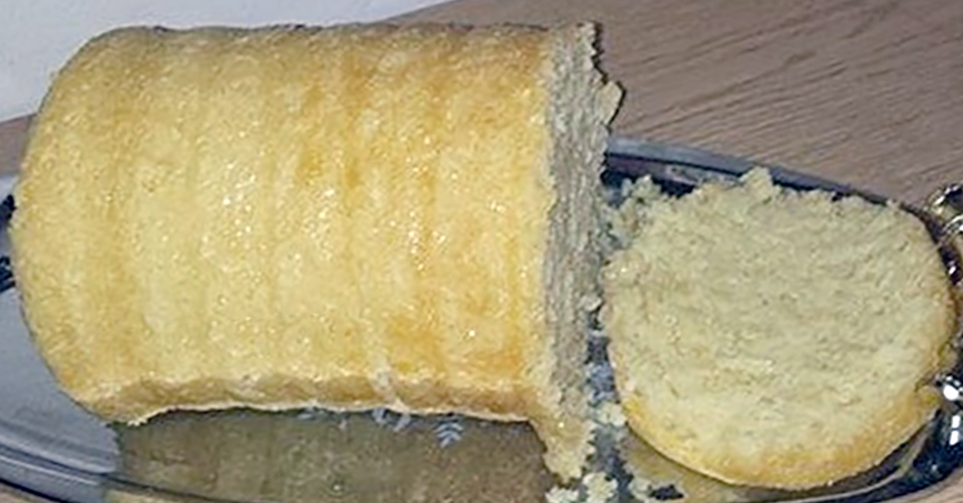 steamed white ground maize kernel bread on a silver tray with one slice cut off
