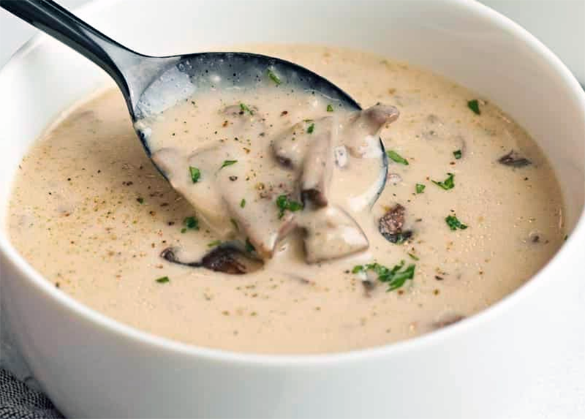 creamy mushroom soup in a soup bowl with a spoon