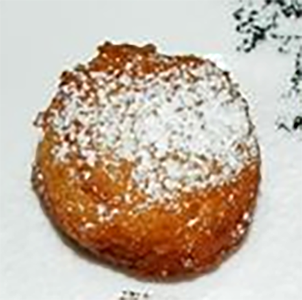 Nuegados de Yucca y Masa on a plate dusted with icing sugar