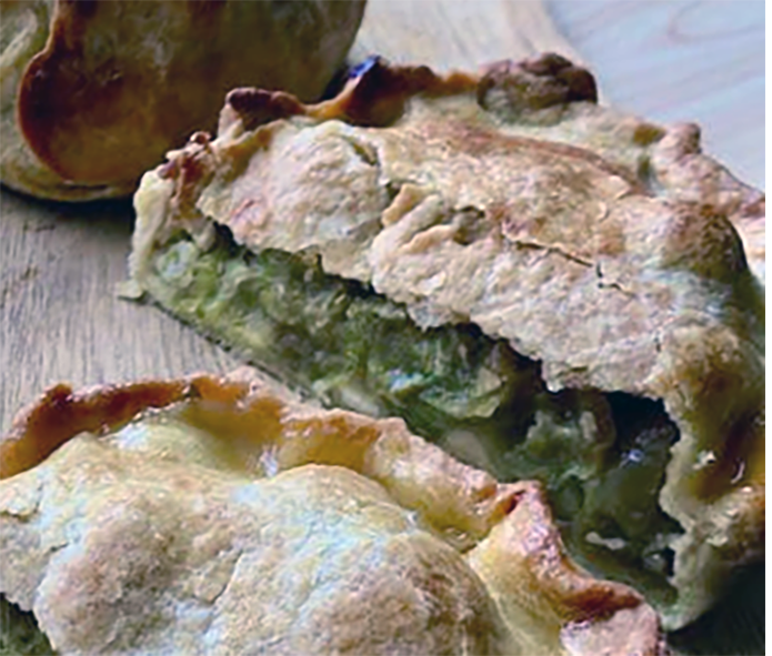 raised oldbury tart split in half to reveal the gooseberry filling