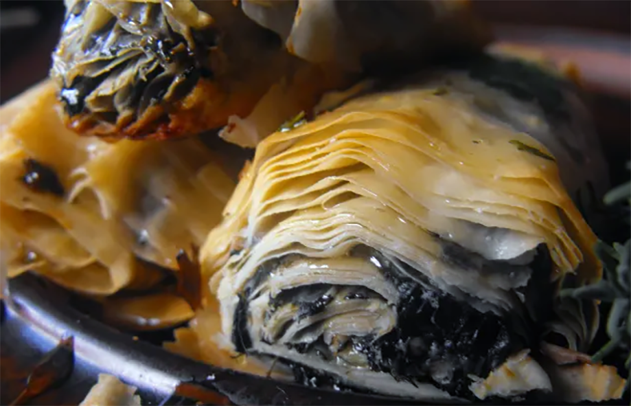 filo rolls with oxeye daisy greens with nuts and honey in a marscarpone base piled on a plate