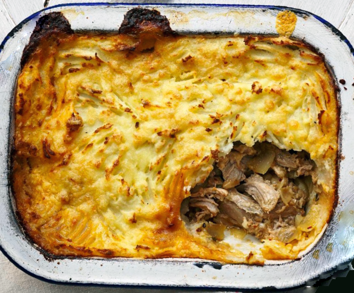 duck cottage pie in a baking dish, with the bottom right corner removed to reveal the filling