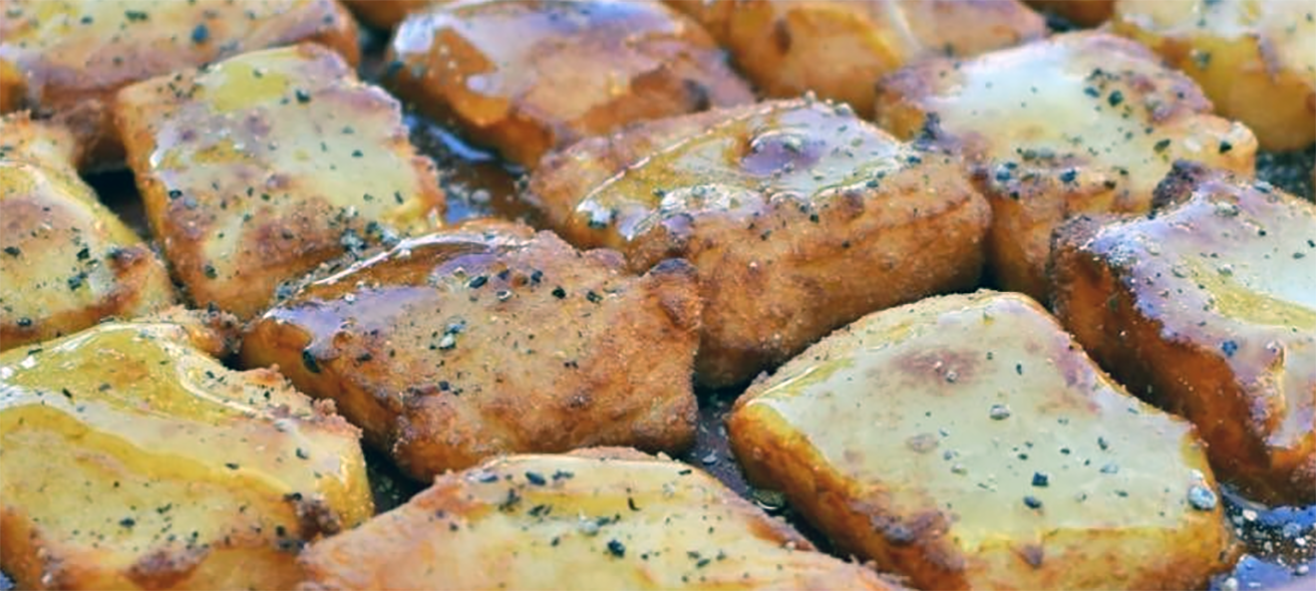almond fritters drizzled with honey arranged on a plate