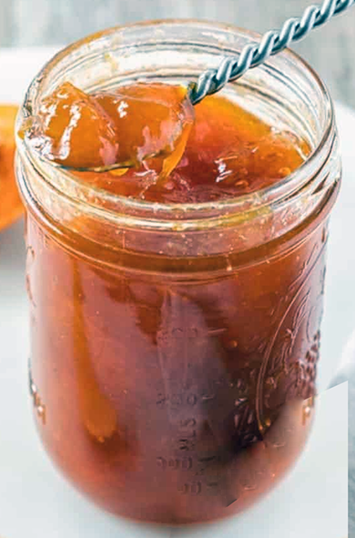 apricot marmalade in a jam jar with a spoon