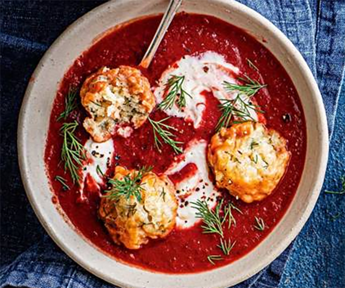 beetroot soup garnished with sour cream and meat dumplings