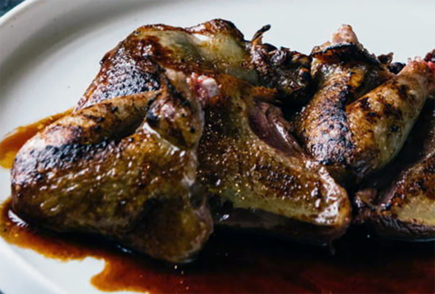 pigeon bonne femme in red wine sauce served on a plate