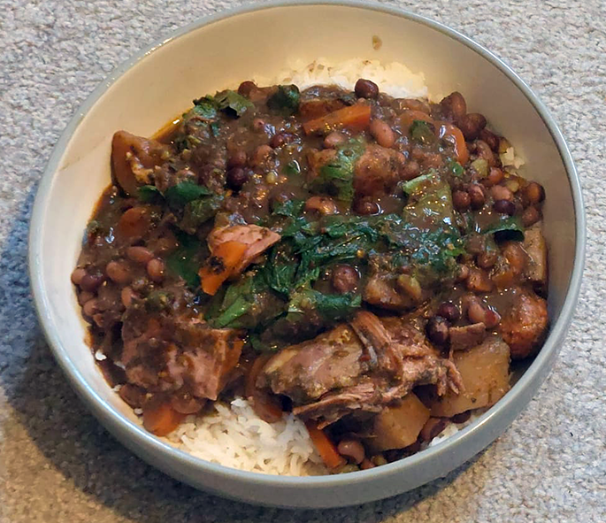 Pork and beans stew with wild greens on a bed of rice