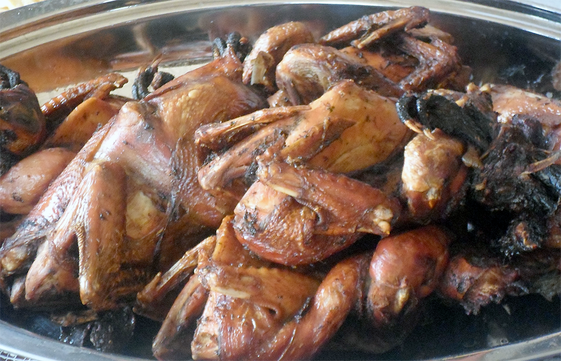 barbecued spatchcocked chickens in a steel serving dish
