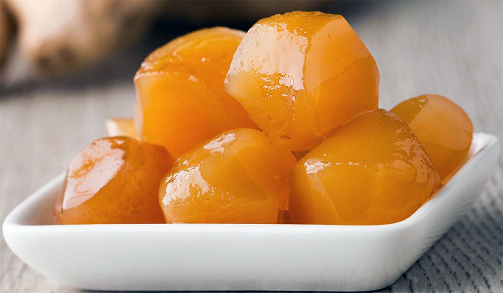 preserved ginger in syrup piled on a small white dish