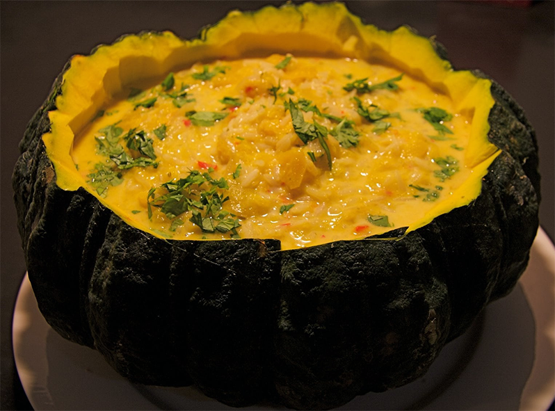 pumpkin and rice laksa served in a hollowed out pumpkin half