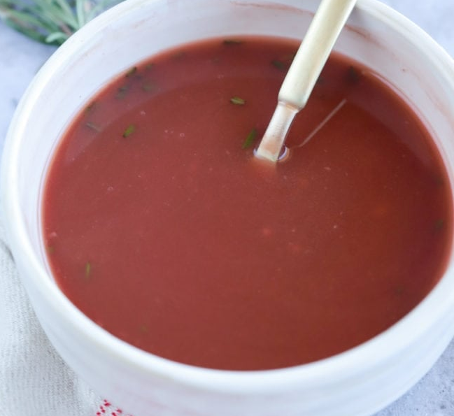 redcurrant jus or sauce in a white bowl with a spoon