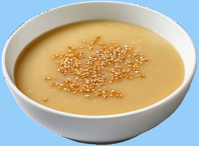 soup of ground rice, ground sesame seeds and ground peanuts in a bowl garnished with whole sesame seeds