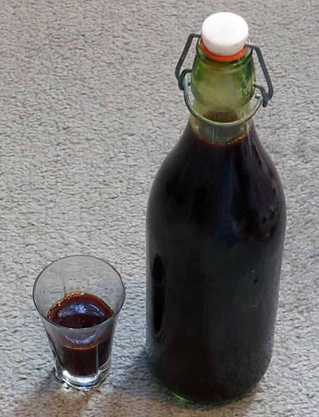 shot glass full and unopened bottle of winter fruit syrup