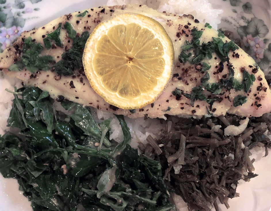 fried smoked catfish fillet served on a bed of wild seashore greens and pickled hop shoots garnished with a slice of lemon