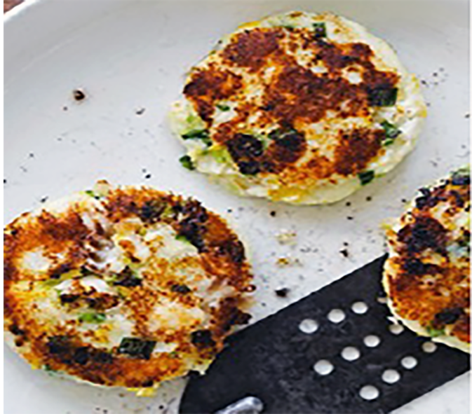 three smoked haddock and champ cakes arranged on a plate