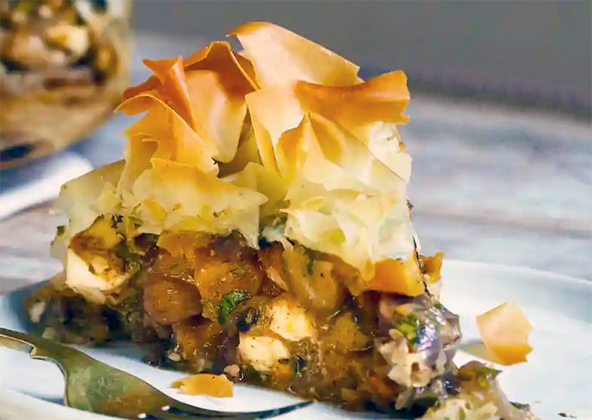slice of filo pastry topped pie with a spiced chestnut, feta and squash base on a plate