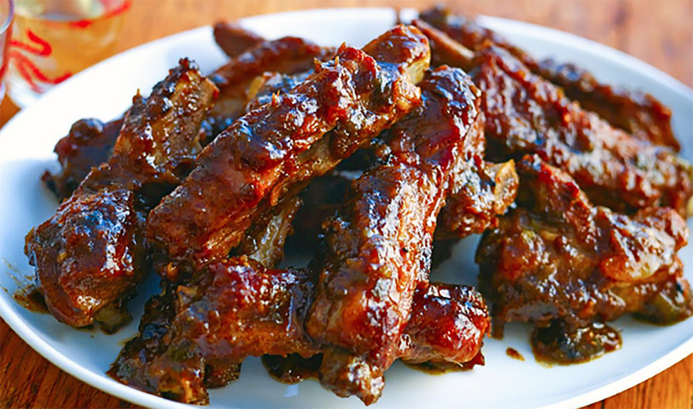 spare ribs in spicy orange sauce piled on a plate