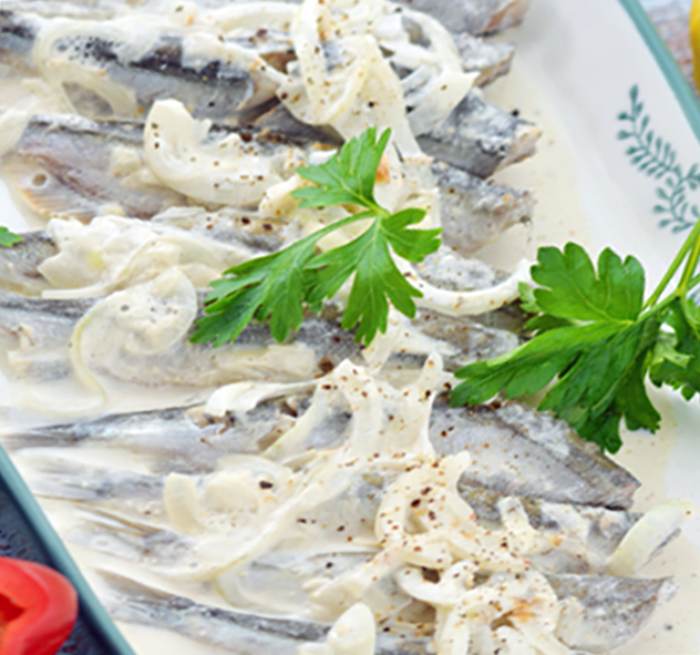 smoked sprats served in sour cream with onions