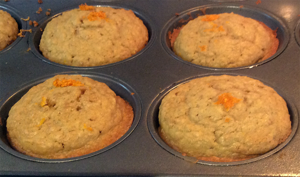 sticky orange oatmeal muffins in a metal muffin tin
