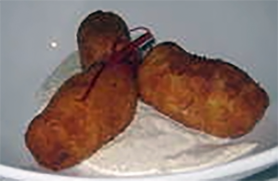 three sweetbread croquettes on a bed of white sauce