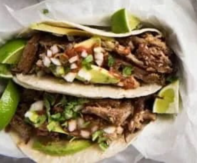 two taco shells filled with pork carnitas