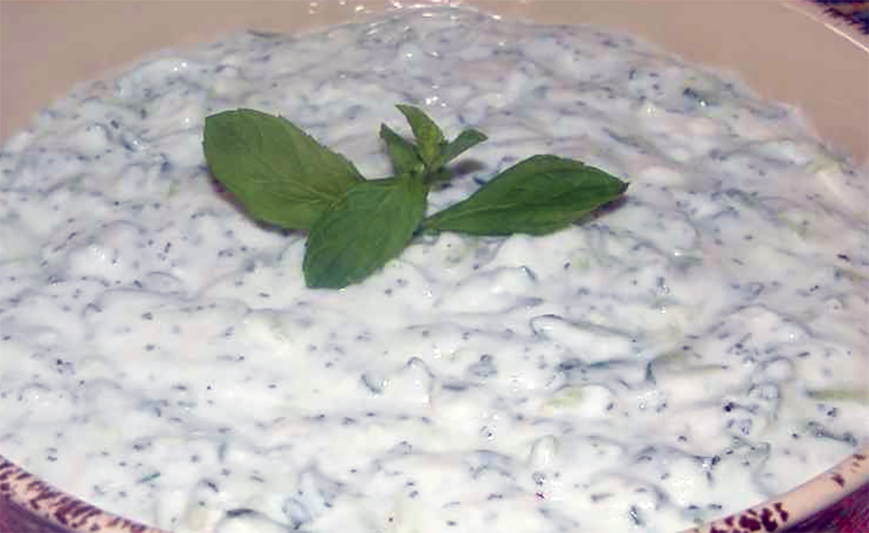 talattouri, cucumber in yoghurt sauce in an earthenware dish with a sprig of mint