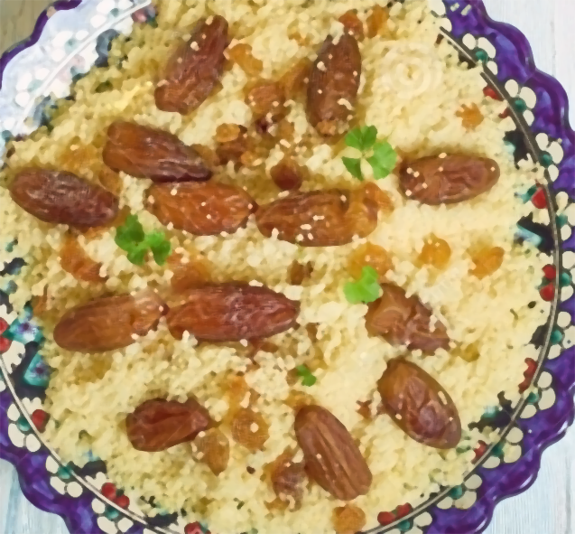 saffron and raisin couscous served on a decorated plate garnished with dates