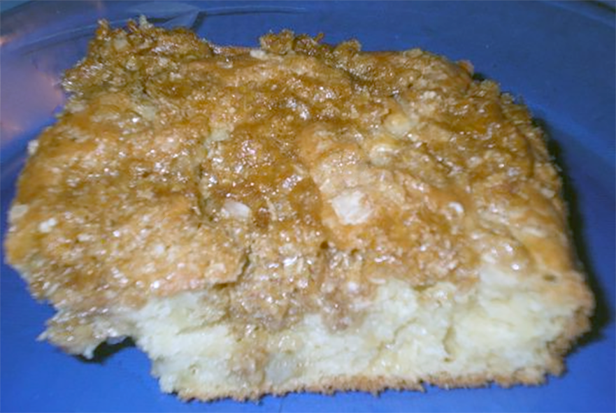 square of apple grunt cake on a blue serving dish
