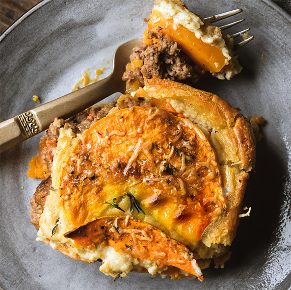 Slice of Armenian butternut squash moussaka on a plate with a fork