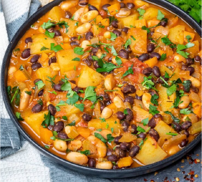 stew of potatoes, carrots and beans flavoured with avocado leaf served in a metal dish