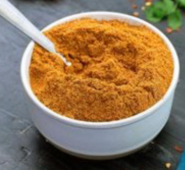 avocado leaf spice blend in a white bowl with a spoon