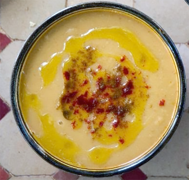 bissara served in a bowl garnished with spices and olive oil