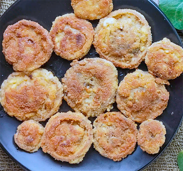 breaded and fried saffron milk caps on a black plate