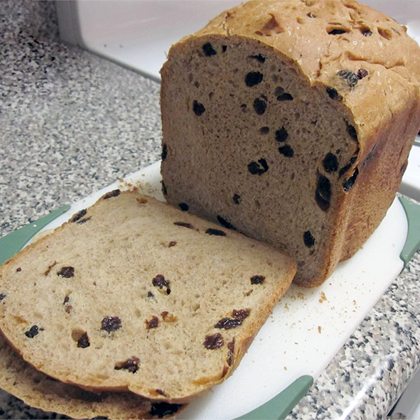 yeasted cherry and raisin sweet bread sliced on a chopping board