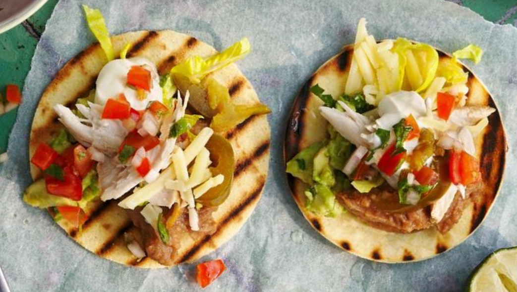 two chicken tostadas on a sheet of greaseproof paper