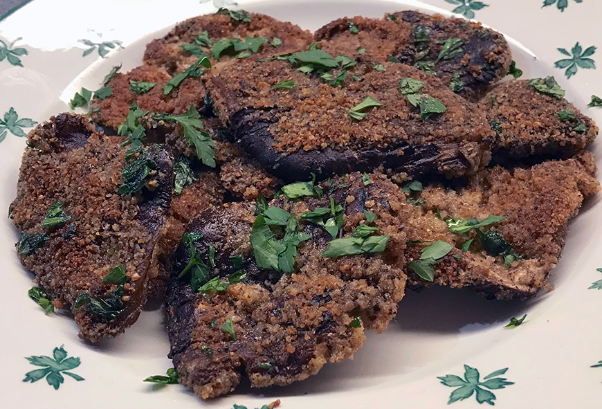 crispy bay boletes with a breadcrumb, anchovy and garlic topping served piled on a plate