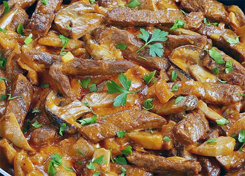 beef stroganoff simmering in a frying pan