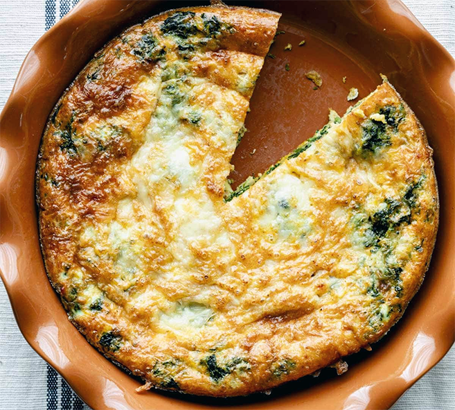 Baked spinach with eggs turned out onto an earthenware dish and with a wedge removed