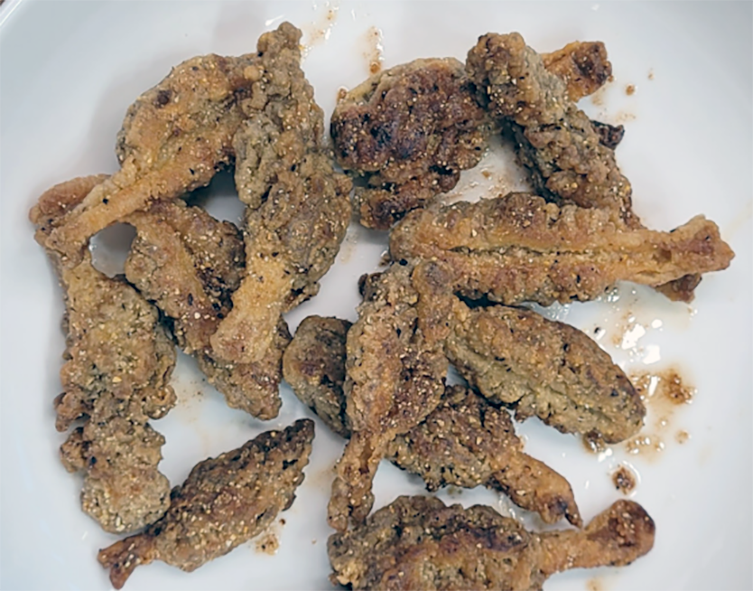 morels fried in a cornmeal crumb coating arranged on a white plate