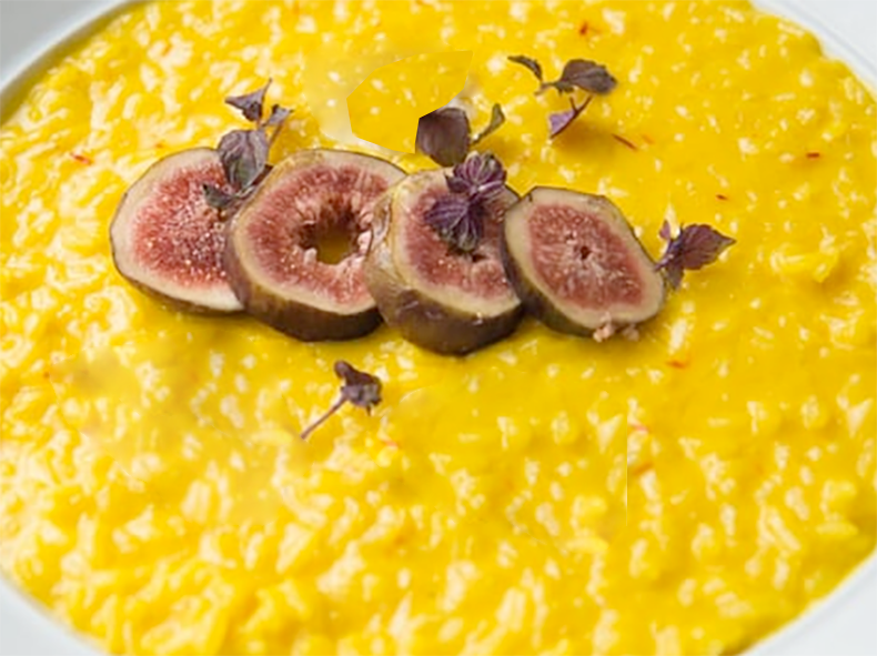 saffron and fig risotto in a dish with a garnish of sliced figs
