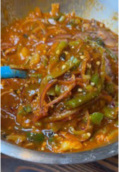 salsa de rajas in a steel bowl with a blue spoon