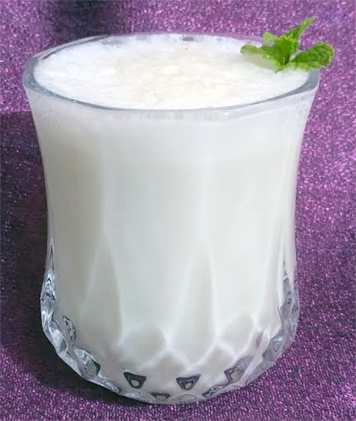laban served in a glass and garnished with a sprig of mint