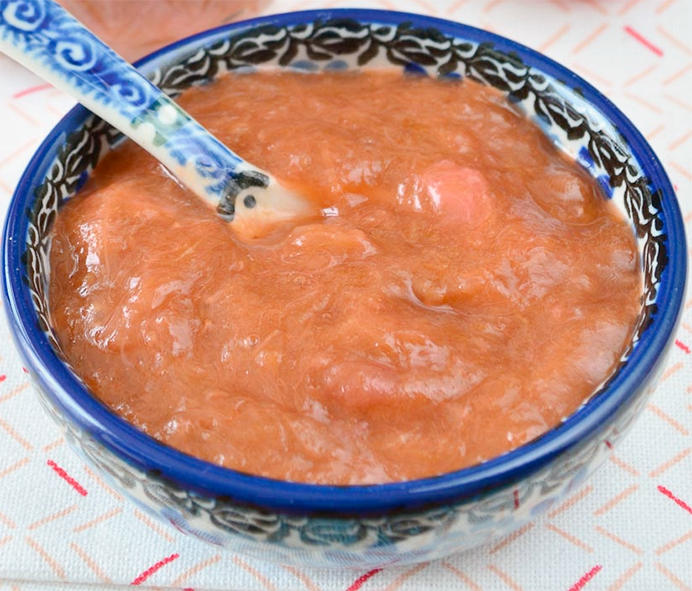 strawberry and rhubarb compote presented in a bowl with a spoon
