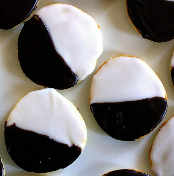 Americaner biscuits iced with half black and half white on a white dish