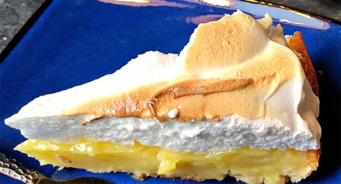 slice of apple meringue pie on a blue plate