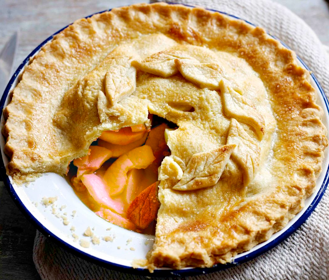 Deep dish apple and redcurrant pie with one wedge removed to reveal the filling