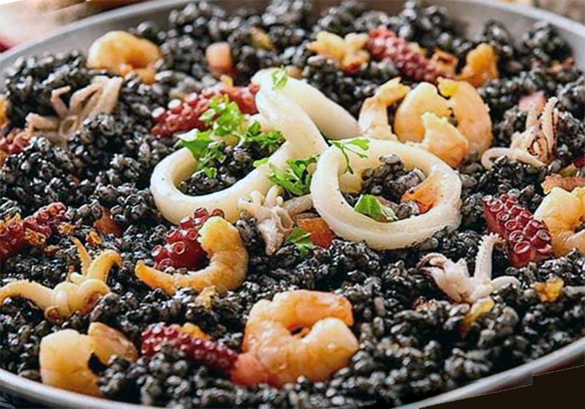 Spanish black rice with seafood piled on a serving tray