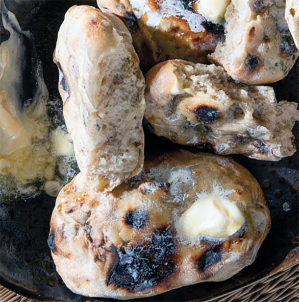 Askoek loaves on a plate spread liberally with butter