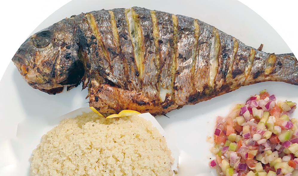 fried dorade fish served with attieke (cassava couscous) and a chopped salad