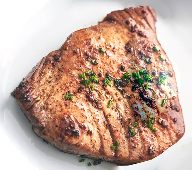 baked tuna steak served garnished with herbs